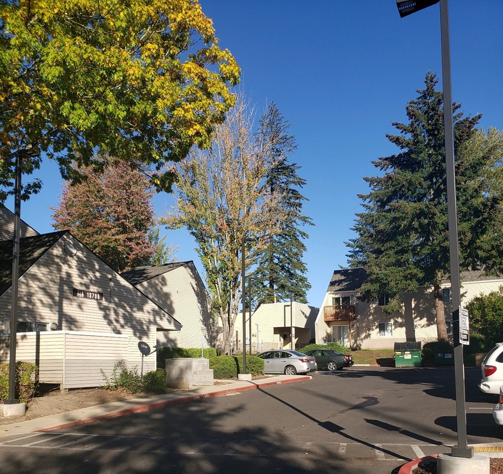 a city street with houses and trees and a blue sky