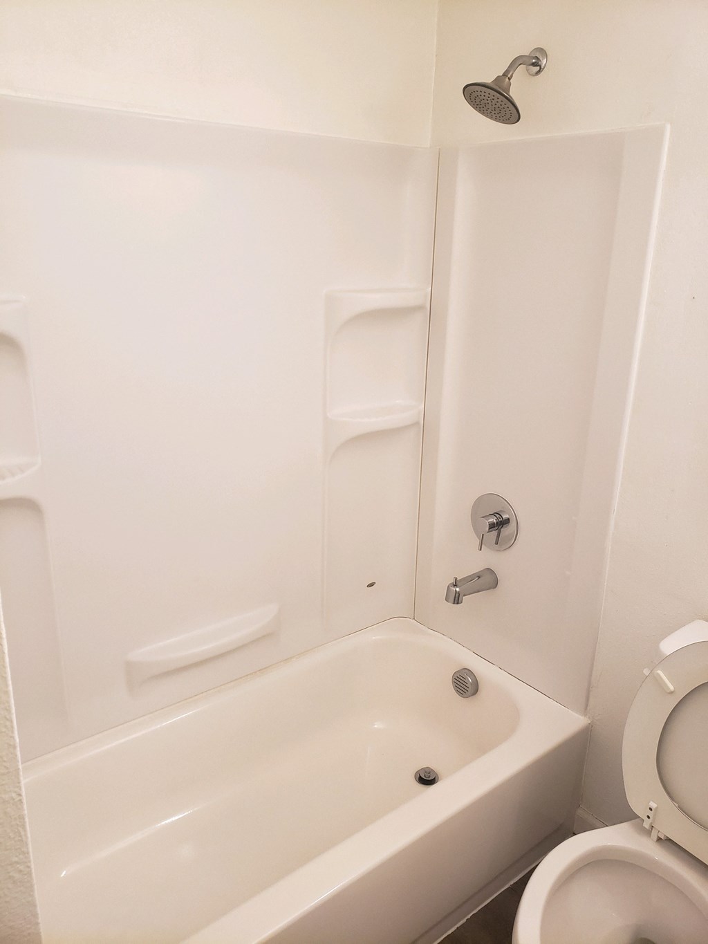 a white bathroom with a tub and a toilet