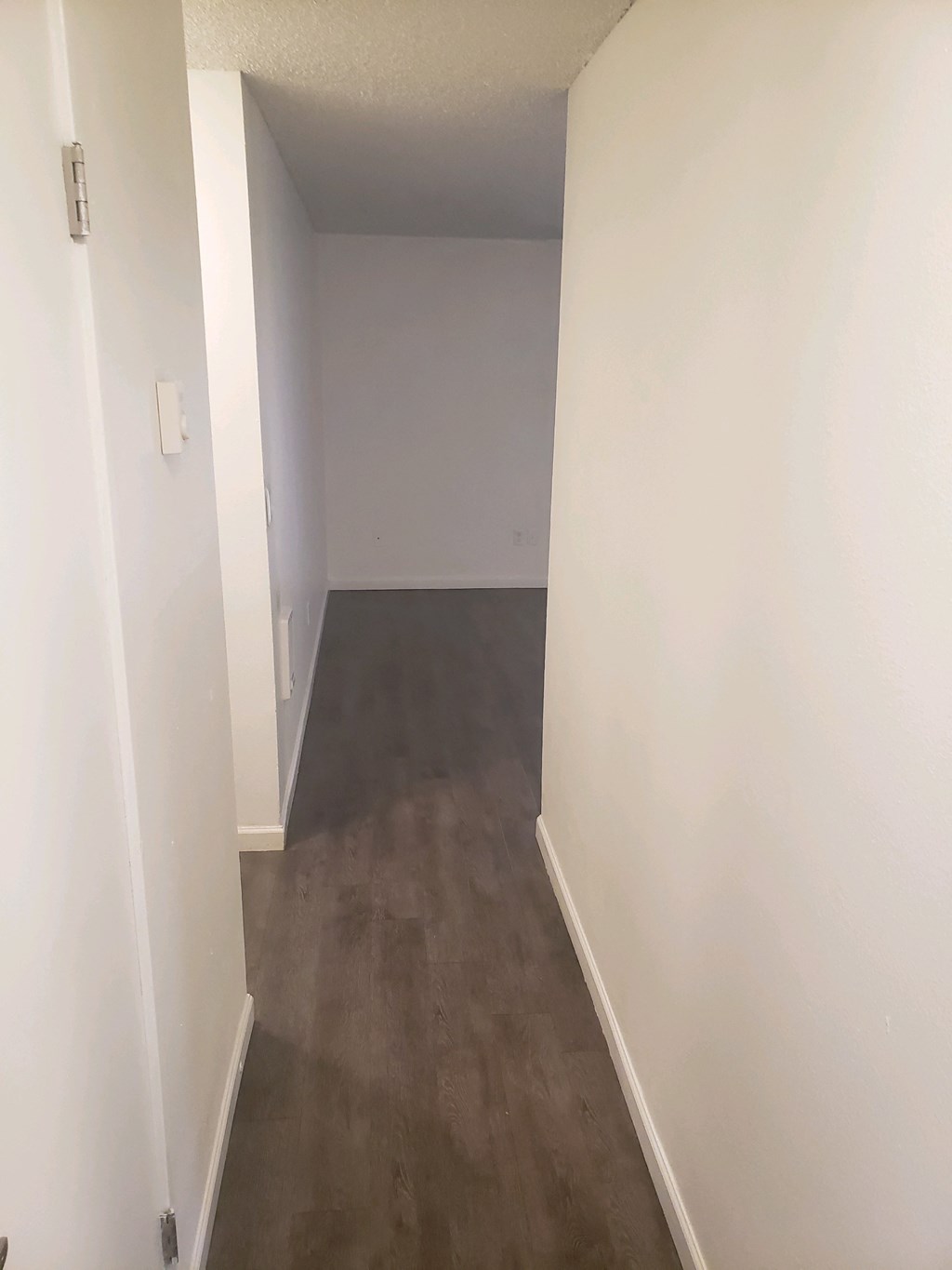 an empty room with white walls and concrete floors