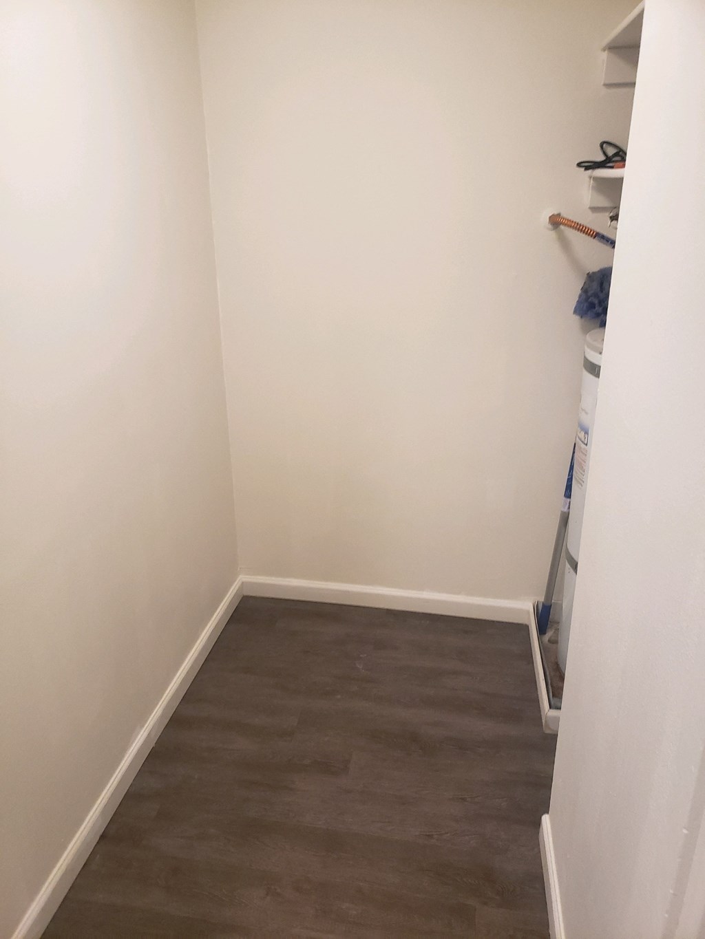 a small room with white walls and wood flooring