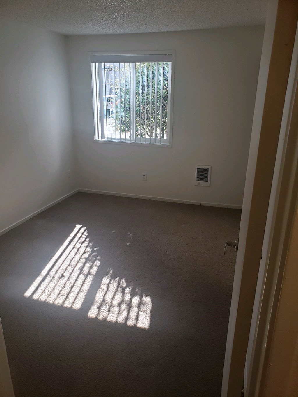 an empty room with sunlight coming through a window