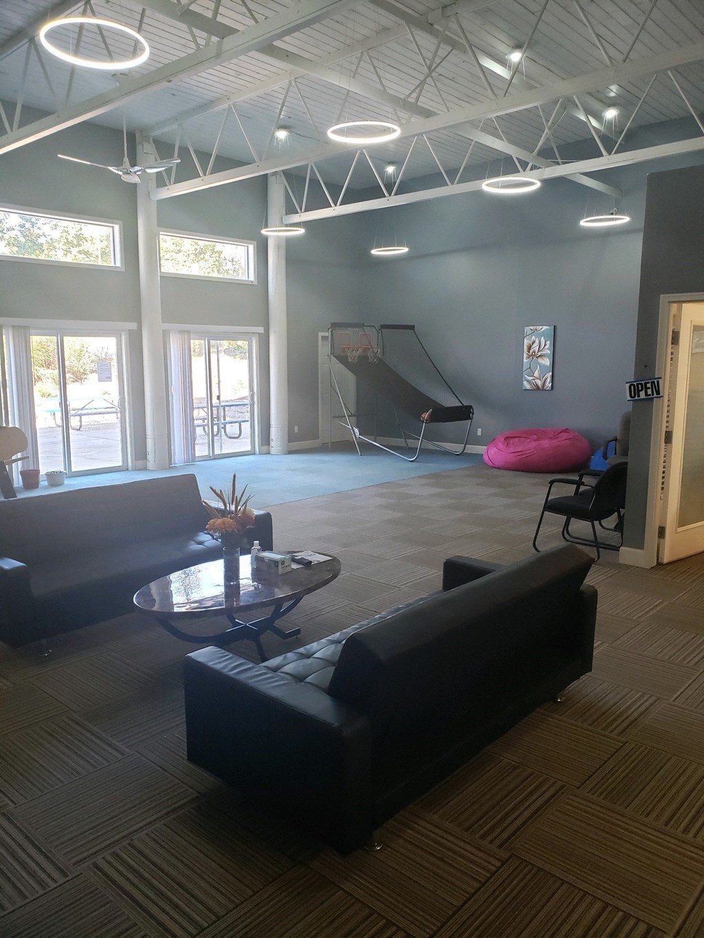 a large room with couches and a skateboard in the corner