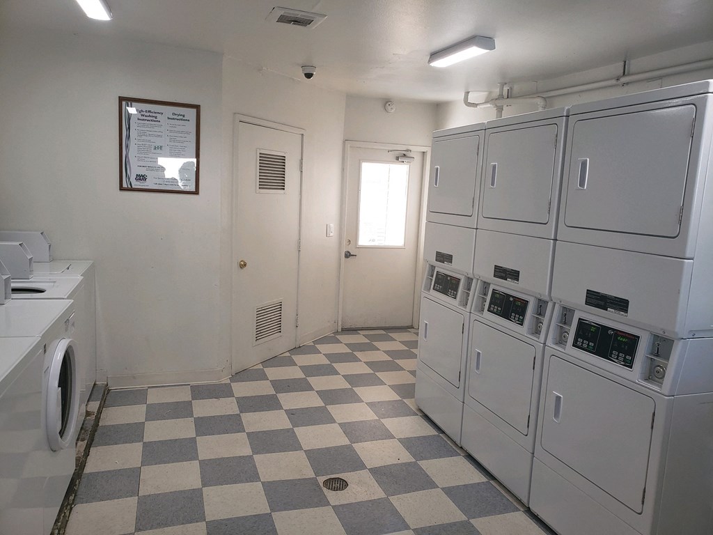 a laundry room with white appliances and a checkered floor