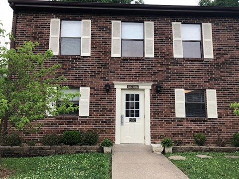 A brick building with a white door and windows.