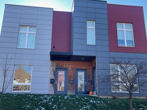 A modern house with a grey, red and blue exterior.