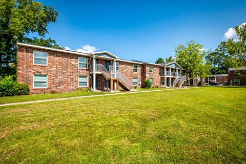 A brick building with a green lawn in front.