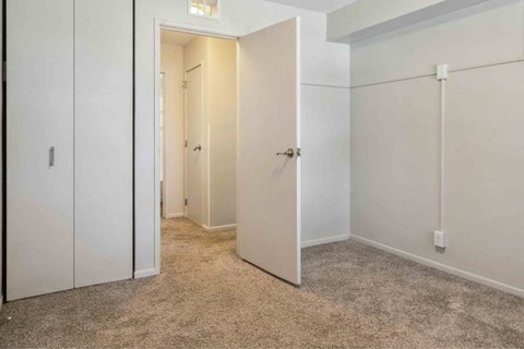 A white door is open in a room with a carpeted floor.
