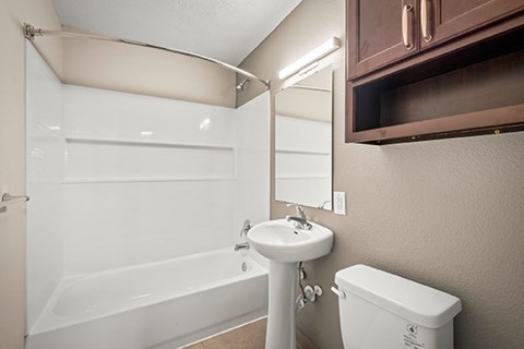 A white sink is next to a white toilet in a bathroom.