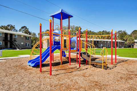 A playground with a blue slide and yellow and red structures.