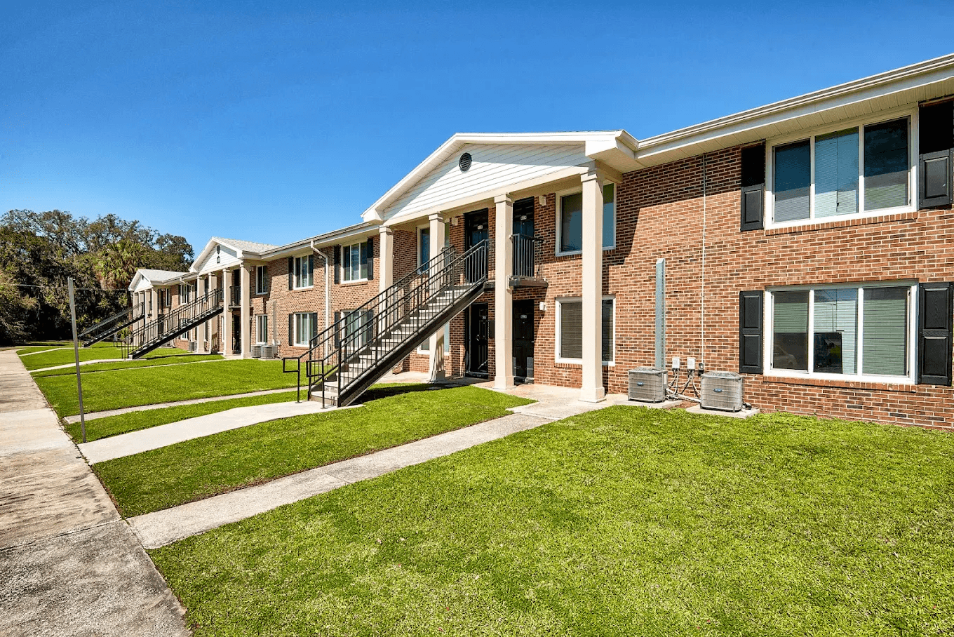 A row of houses with green lawns in front.