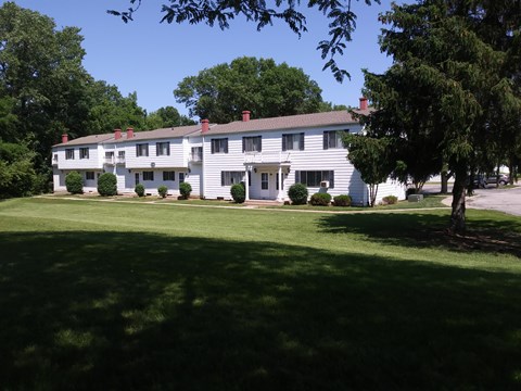 A white building with a green lawn in front.