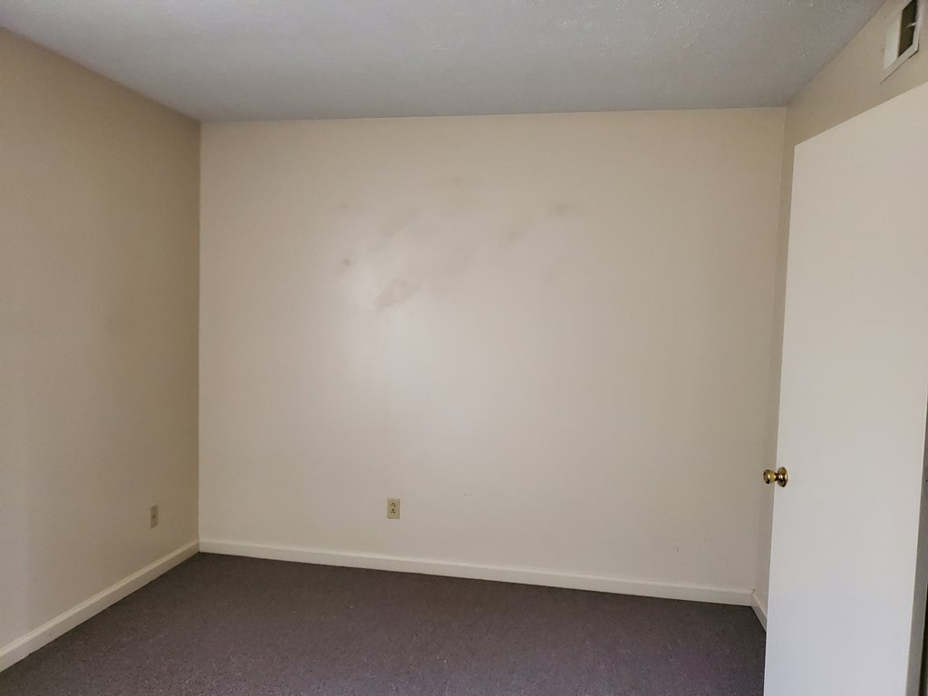 an empty room with white walls and a door