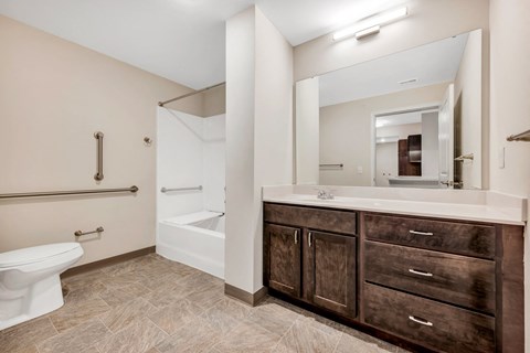 a bathroom with a large mirror and a toilet and a sink