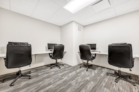 a room with four desks and leather chairs