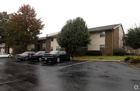 a parking lot with cars in front of a building