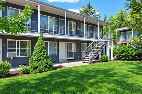 A sunny day at a two-story building with a balcony and stairs.