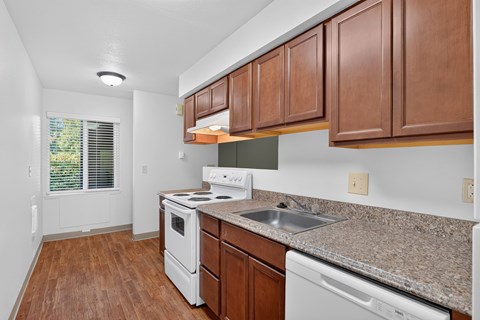 A kitchen with brown cabinets and white appliances.