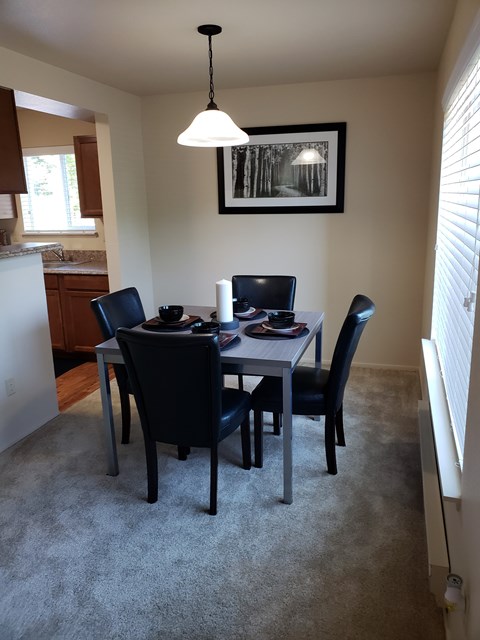 A dining room with a table and chairs.