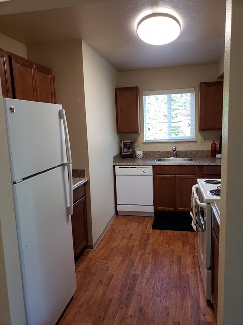 A small kitchen with a white refrigerator and a white dishwasher.