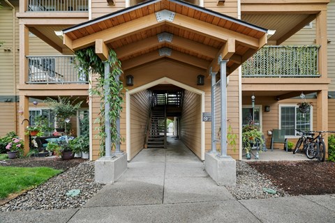 A building with a covered walkway and a bicycle parked outside.