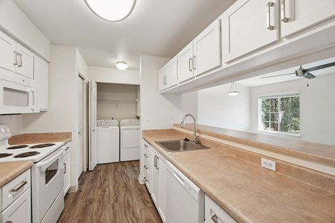 A kitchen with white cabinets and a wooden countertop.