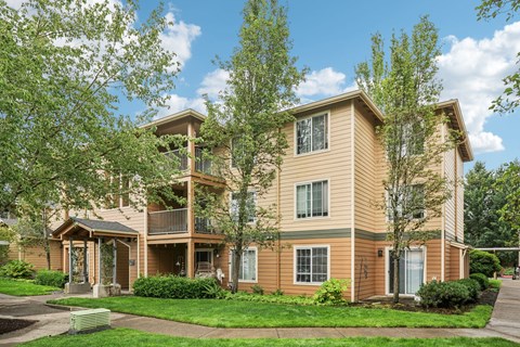 A two-story apartment building with a balcony on the second floor.
