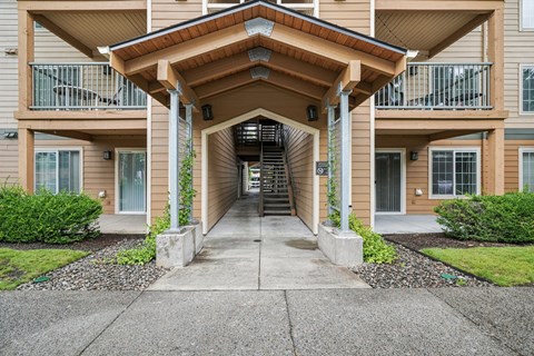 A building with a brown roof and a staircase leading to the entrance.