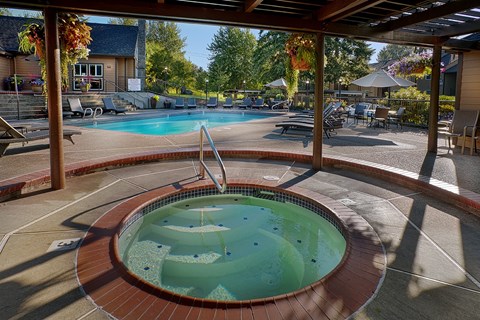 A hot tub sits in the middle of a patio.