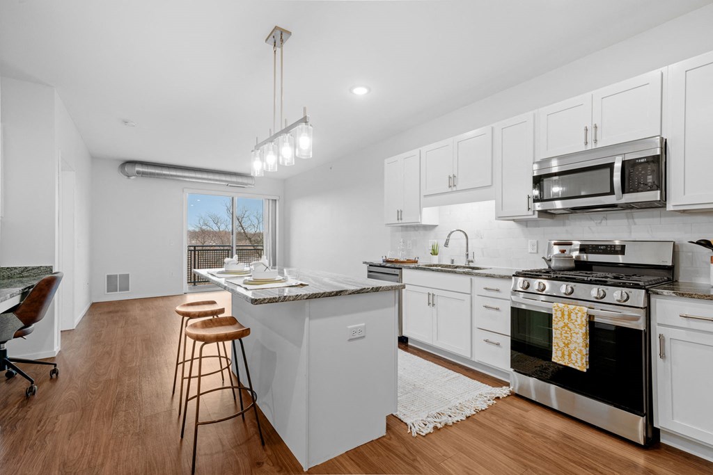 A kitchen with white cabinets and a black stove top oven.
