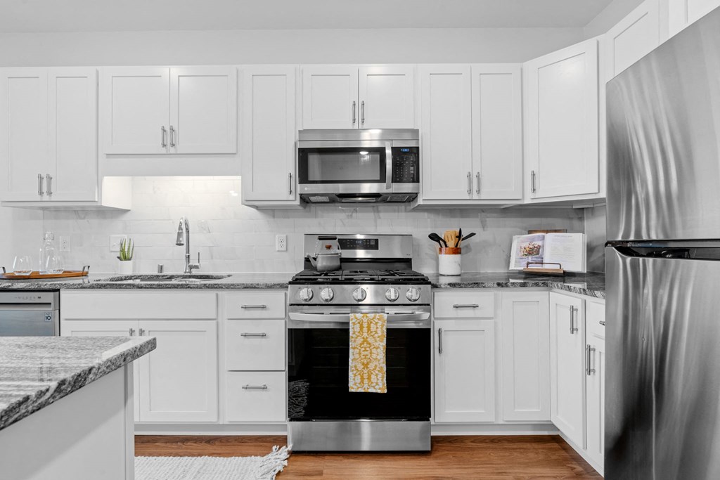 A modern kitchen with white cabinets and stainless steel appliances.
