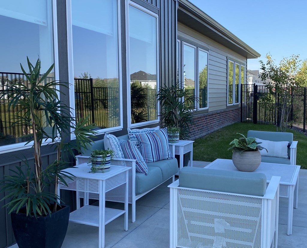 a patio with white furniture and potted plants
