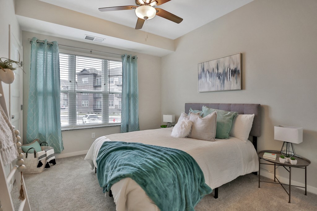 a bedroom with a bed and a ceiling fan
