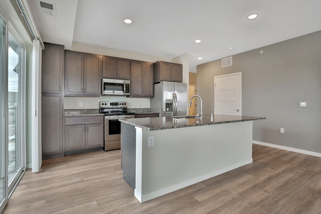 a kitchen with a large island and stainless steel appliances