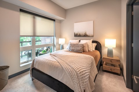 a bedroom with a bed and a large window