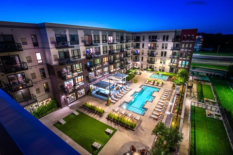 an overhead view of an apartment complex with a pool at night