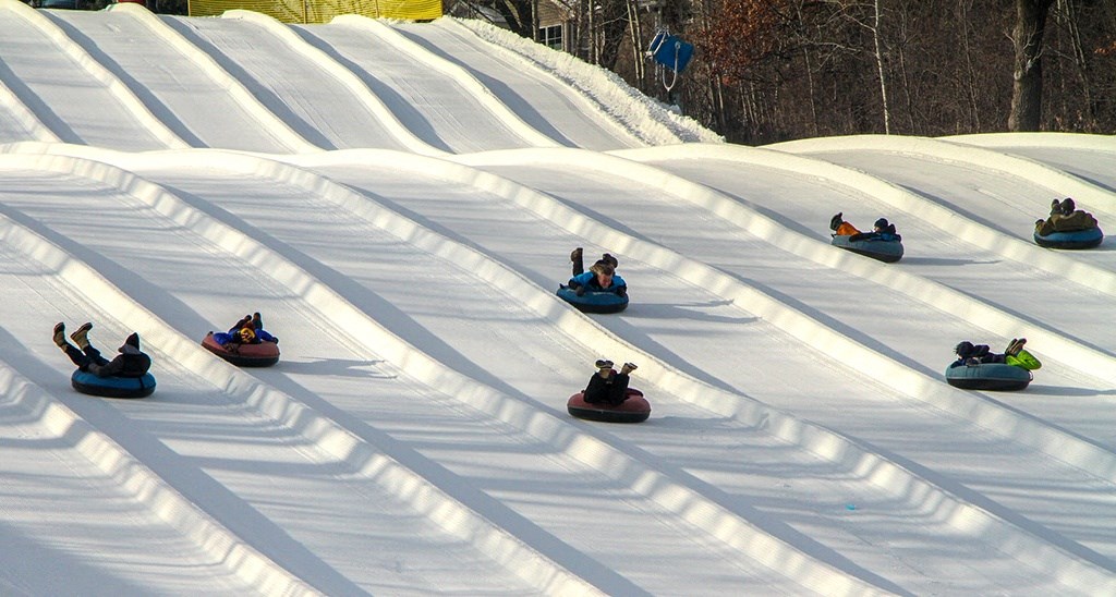 a group of people snowboarding down a snow covered slope