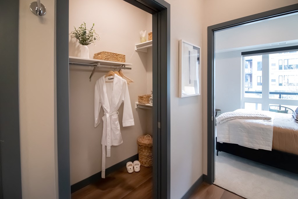 a white robe hangs on a wall next to a mirror in a bedroom
