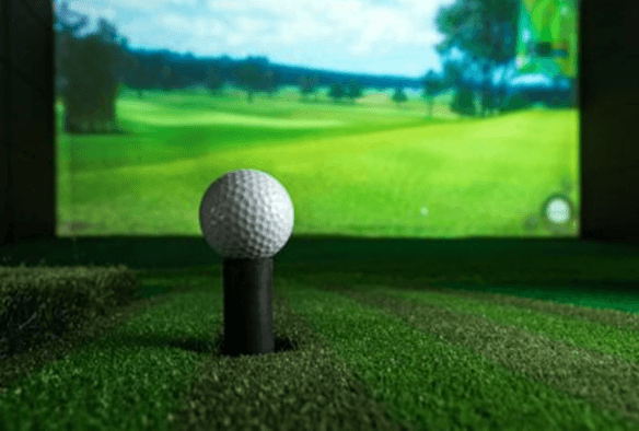 a golf ball on a tee in front of a tv screen