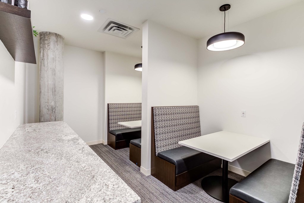 a meeting room with a white table and black leather chairs