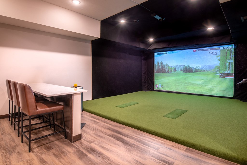 a game room with a projector screen and a table and chairs