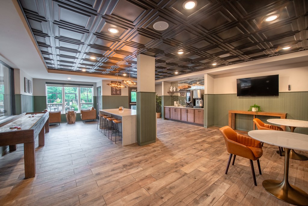 a communal area with tables chairs and a tv in a lobby