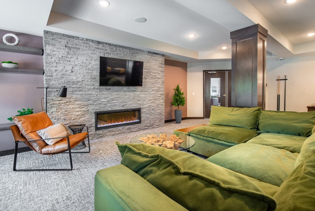 a living room with green couches and a fireplace