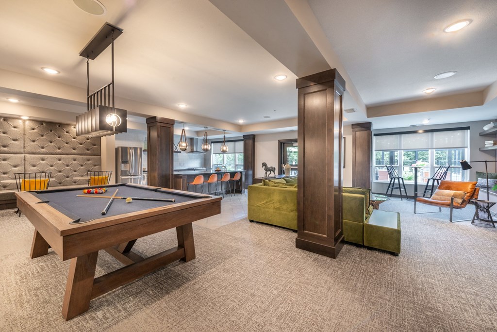 a spacious game room with a pool table and a bar