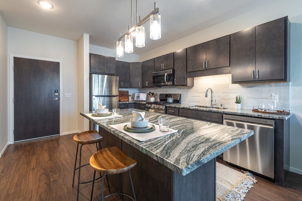a kitchen with stainless steel appliances and a marble counter top
