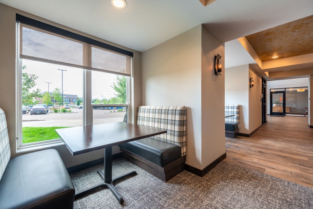 a room with a table and chairs and a large window