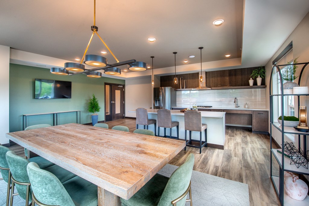 a dining room and kitchen with a wooden table and chairs