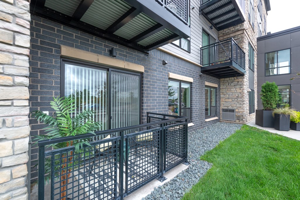 the yard of a condo with a balcony and grass
