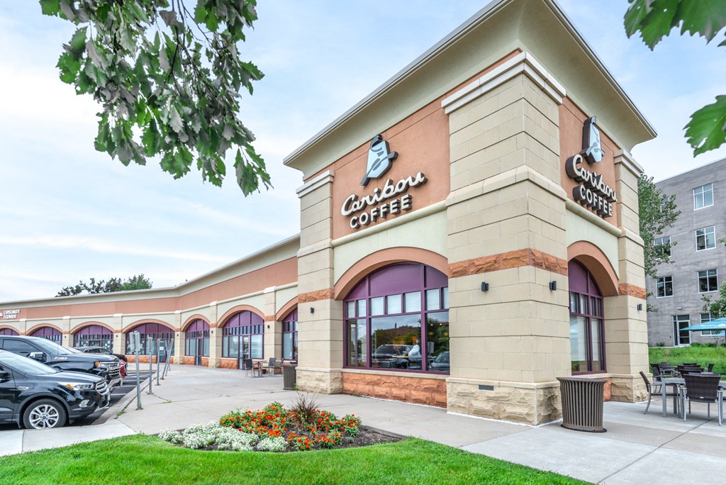 the facade of a coffee shop with cars parked outside