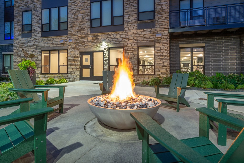 an outdoor patio with a fire pit and benches