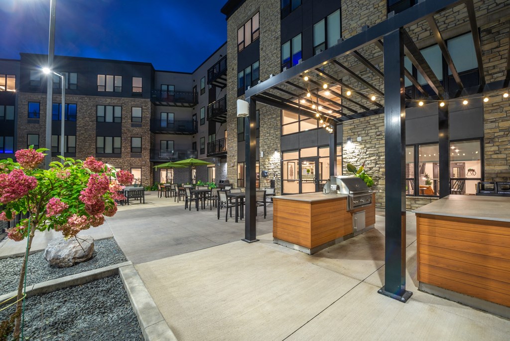 a patio with a grill and a bar at night